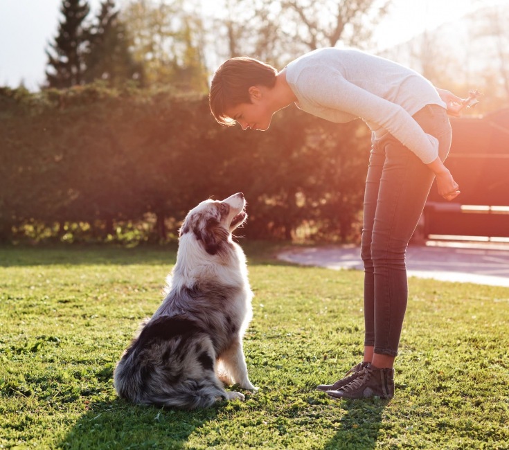 lifestyle image of a woman and a dog outdoors